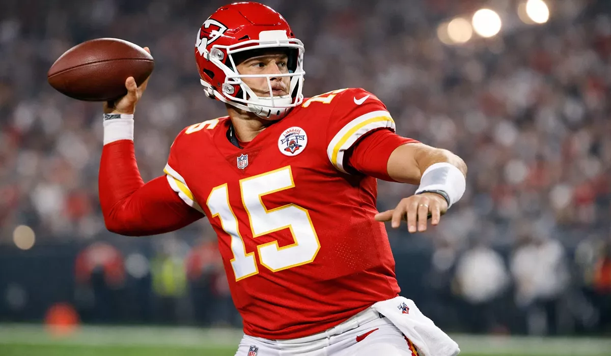 NFL quarterback throwing football during professional game at packed stadium